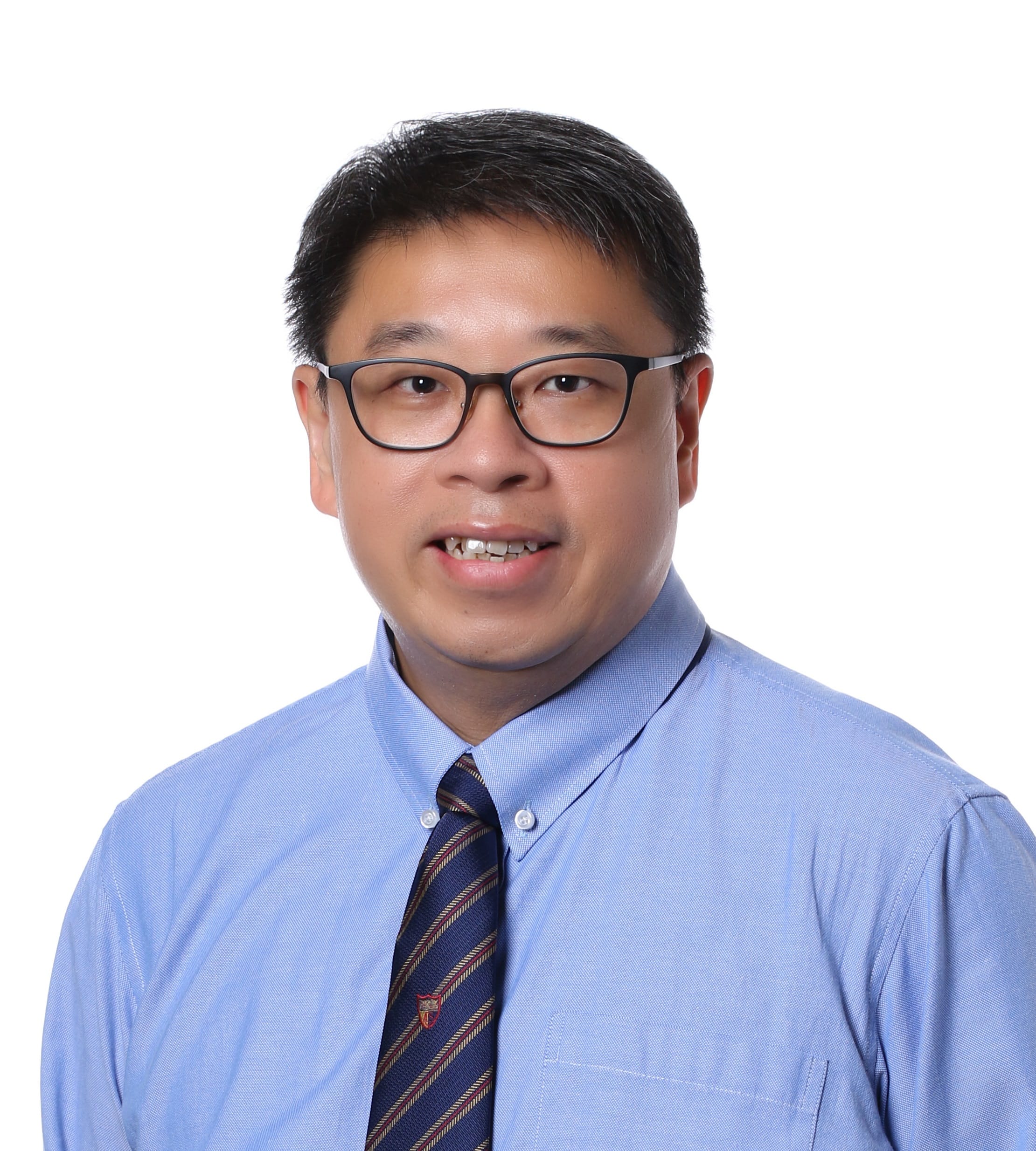 A man with dark-rimmed glasses wearing a light blue shirt and striped tie, smiling against a white background.